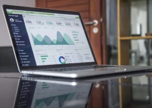A laptop displaying media buying insights through an analytics dashboard with performance charts and campaign metrics.