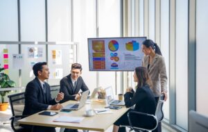 A team of media buyers reviews campaign data on a screen during a meeting on best practices for setting goals in ctv advertising.