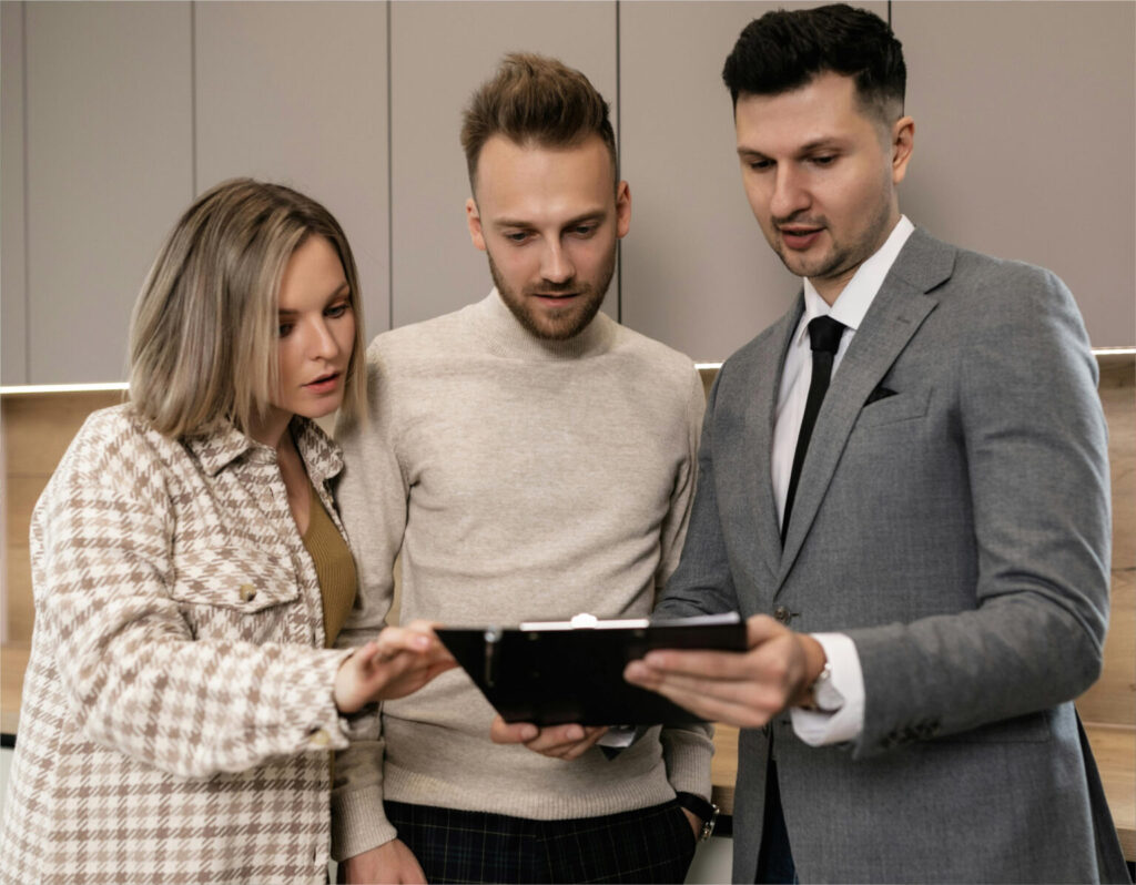 Three colleagues reviewing information on a tablet.