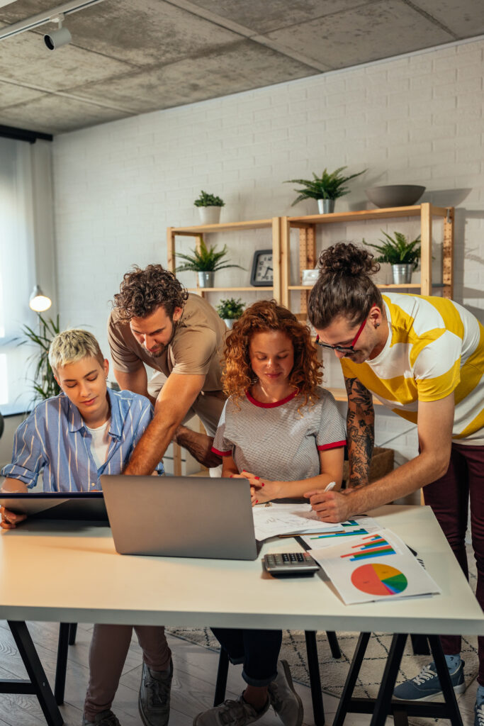 Agency media team reviewing a campaign plan together around a laptop