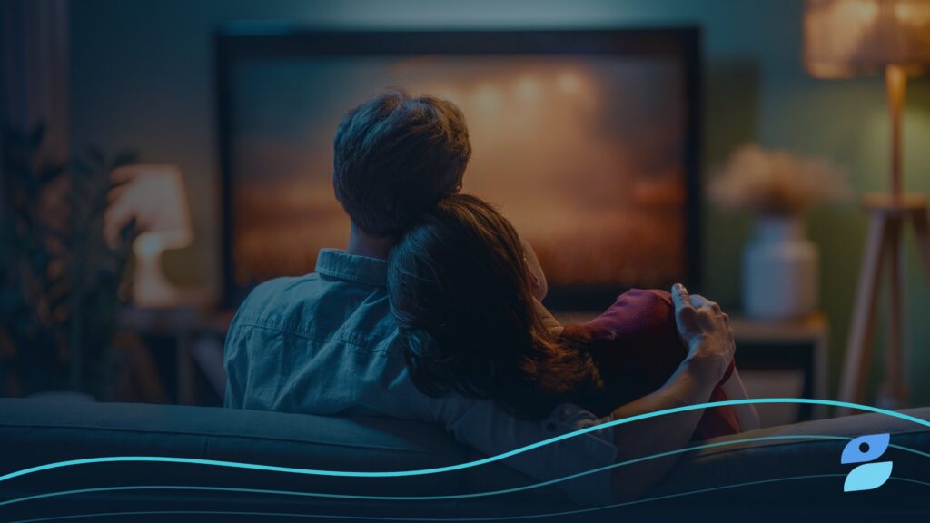 A couple relaxes on a couch watching a streaming show at home, the kind of viewer advertisers ask about when wondering does Apple TV have ads.