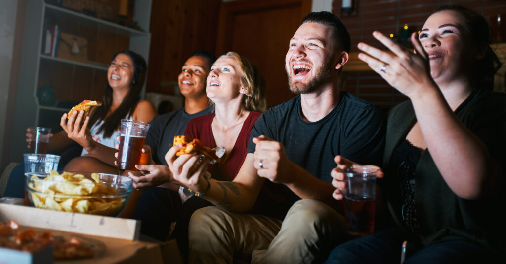 Friends sharing a fast food meal while watching TV
