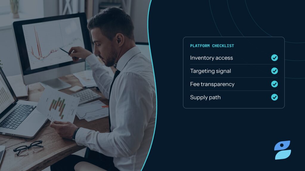 A media trader comparing dashboards on two monitors while evaluating programmatic advertising solutions for inventory access, targeting, and fees.
