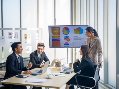 A team of media buyers reviews campaign data on a screen during a meeting on best practices for setting goals in ctv advertising.