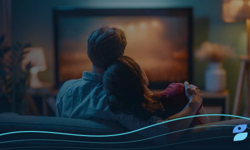 A couple relaxes on a couch watching a streaming show at home, the kind of viewer advertisers ask about when wondering does Apple TV have ads.