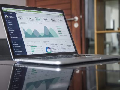 A laptop displaying media buying insights through an analytics dashboard with performance charts and campaign metrics.